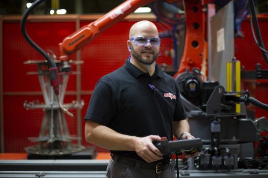 worker in hard hat and safety goggles smiling at camera