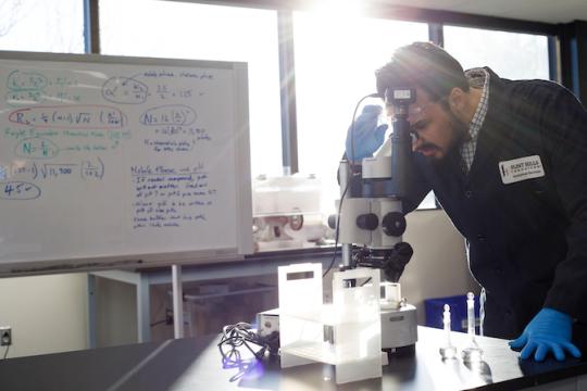 man looking at microscope
